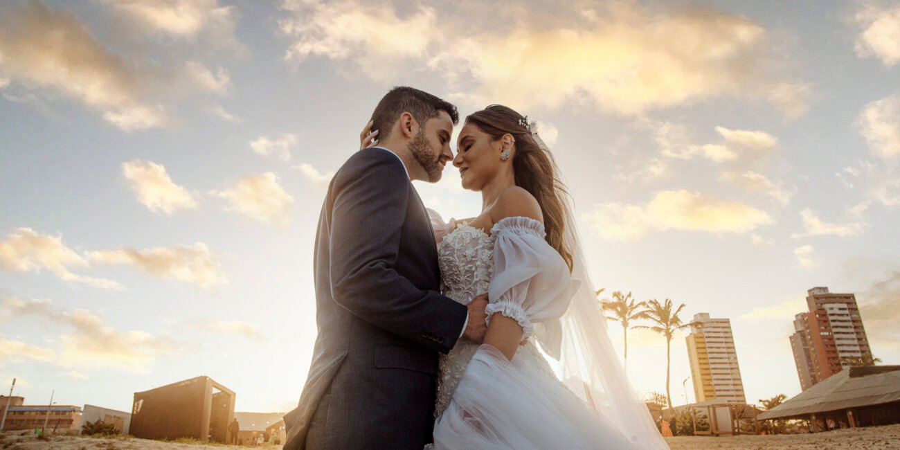 Casal em ensaio na praia do Futuro com o céu dourado do fim de tarde