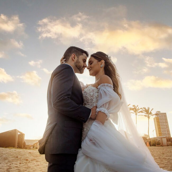 Casal em ensaio na praia do Futuro com o céu dourado do fim de tarde