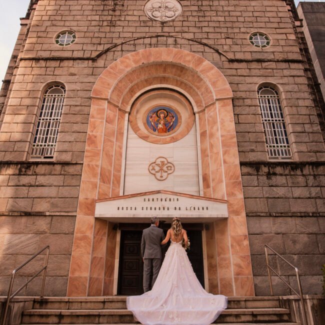 Casamento de Joice e Felipe: Joice sobe a escada de costas, de vestido e cauda longa.