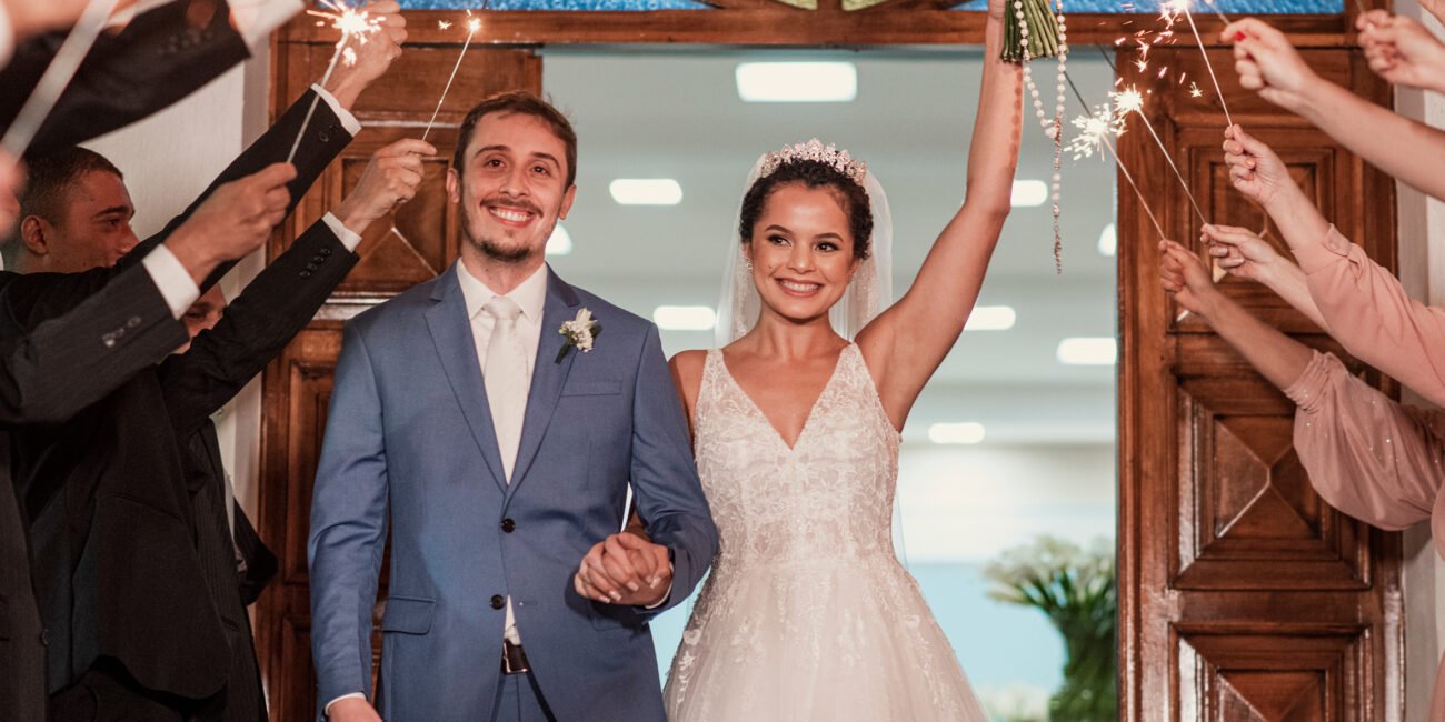 Casamento de Thamires e Flávio: ela ergue o buquê e os dois saem de mãos dadas, entre faíscas.